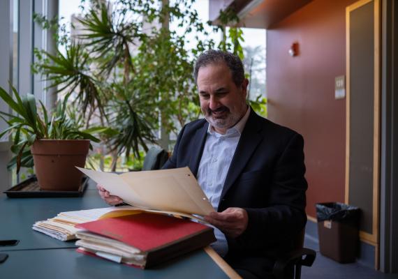Marc Schulz smiling as he looks down at his files