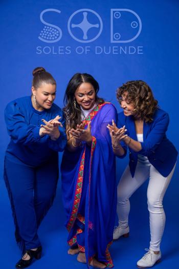 Three dancers in front of a blue background